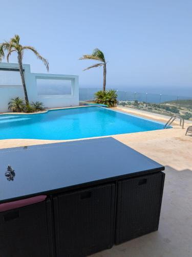 a swimming pool with a table in front of a house at Exclusive luxury villa private pool and garden mnar in Tangier