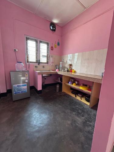 a pink kitchen with a sink and a counter at Luna's Solace-The Rustic Stay-Ease in Guwahati