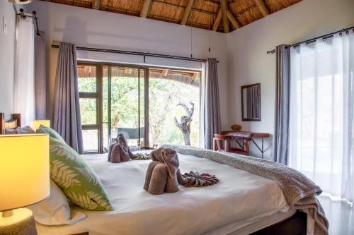 a bedroom with a bed with stuffed animals on it at Lions Place in Grietjie Game Reserve