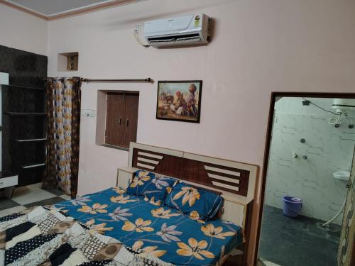 a bedroom with a bed with a blue comforter at Mi HOMESTAY in Bikaner