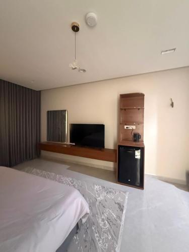 a bedroom with a bed and a flat screen tv at ليالينا in Dammam