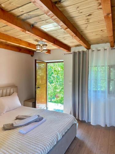 a bedroom with a bed and a large window at Lokthi Guesthaose in Theth