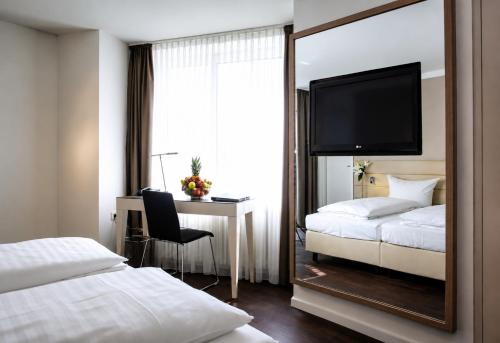 a hotel room with a mirror and a bed and a desk at Manhattan Hotel in Frankfurt