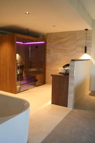 a bathroom with a tub and a sink with purple lights at Spaarnwoude Park Hotel in Velsen-Zuid