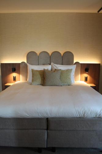 a bedroom with a large white bed with two lamps at Spaarnwoude Park Hotel in Velsen-Zuid