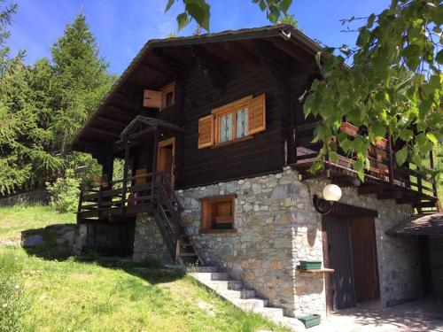 a log cabin with stairs leading up to it at Chalet des Mélèzes in Pila