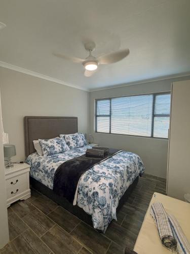 a bedroom with a bed and a ceiling fan at LTB-Waterkant Cottage in Malgas