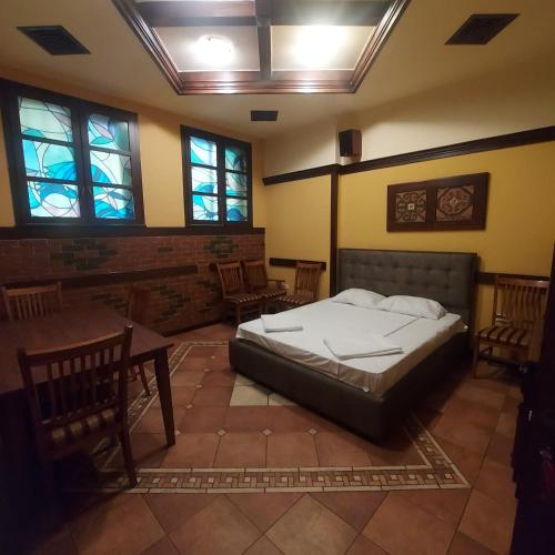a bedroom with a bed and tables and windows at Hotel Jan & in the very center in Yerevan