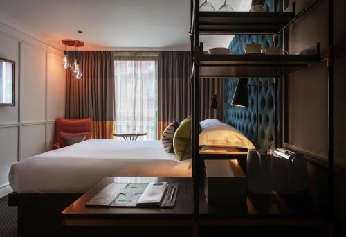a hotel room with a bed and a book shelf at The Guardsman Hotel in London