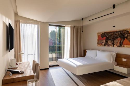 a bedroom with a bed and a large window at Best Western Plus Carolus Park Hotel in Sutri
