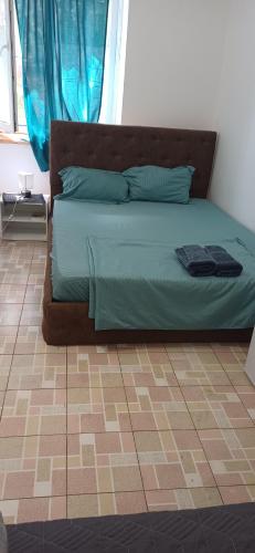 a bed with green sheets and pillows in a bedroom at CASA MEA-Casa Mocanu in Giurgiu