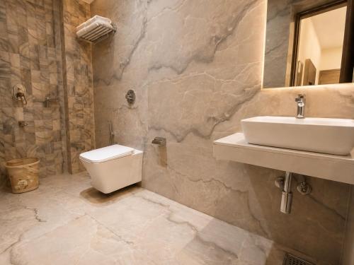 a bathroom with a sink and a toilet at Hotel Beverly Palace Santacruz - Near BKC - Mumbai Airport T1 in Mumbai