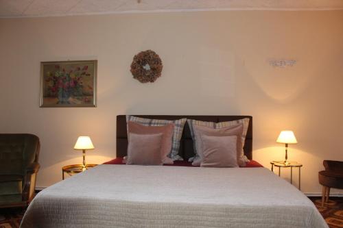 ein Schlafzimmer mit einem Bett, Kissen und zwei Lampen in der Unterkunft Wohnstudio auf Schloss Semlow in Semlow