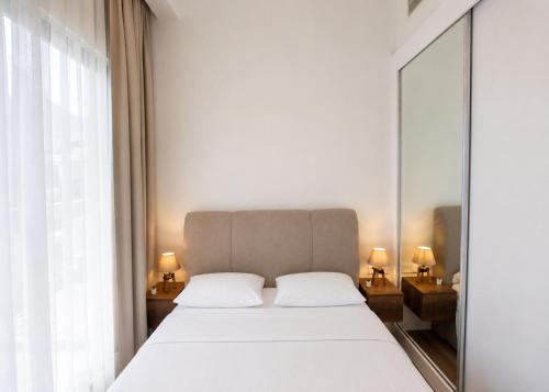 a bedroom with a large white bed and a mirror at Abodos Aqualina D2/1 Fm in Vavilas