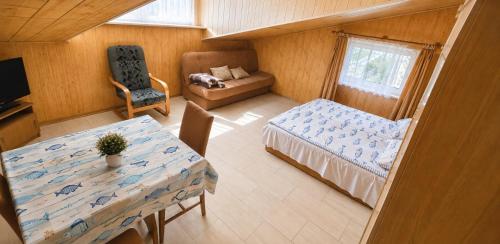 a room with a table and a bed and a chair at Nella - Pokoje gościnne in Ostrowo