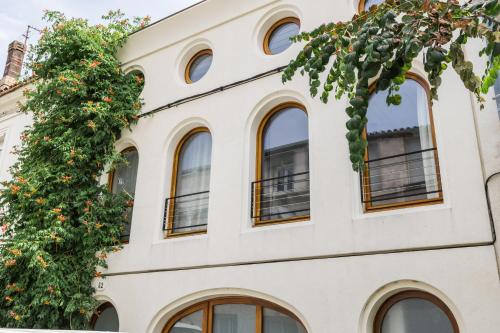 a building with windows and a tree at Outsite Bordeaux - Work, Connect, Explore in Bordeaux