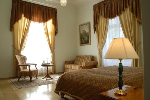 a bedroom with a bed and a chair and a lamp at Bristol Vila Tereza in Karlovy Vary
