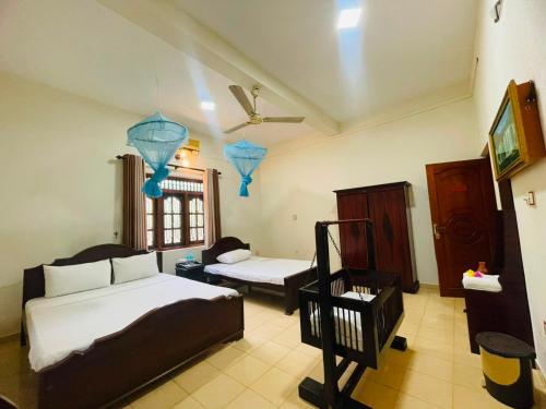 a bedroom with two beds and a couch at Nandawanam Guest House Pasikuda in Kalkudah