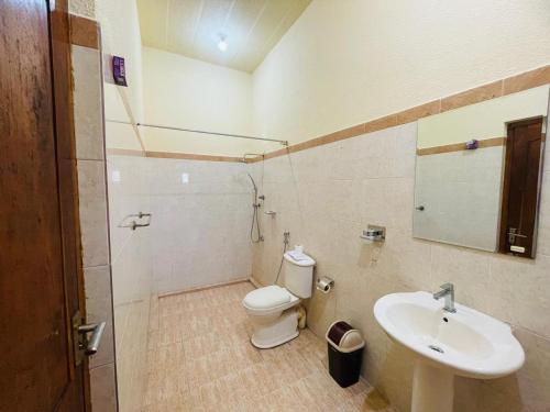 a bathroom with a toilet and a sink at Nandawanam Guest House Pasikuda in Kalkudah