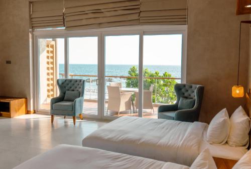 a bedroom with a bed and a view of the ocean at At Kelly's Ambalangoda in Ambalangoda