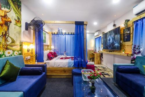 a bedroom with a bed and blue chairs and a couch at DSR Blue Suites in Hyderabad
