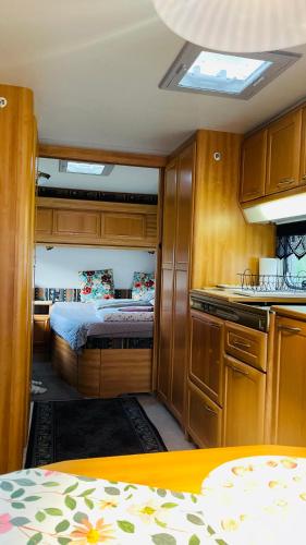 a small room with a bed and a kitchen at Caravan at the Cottage House in Ertenvåg