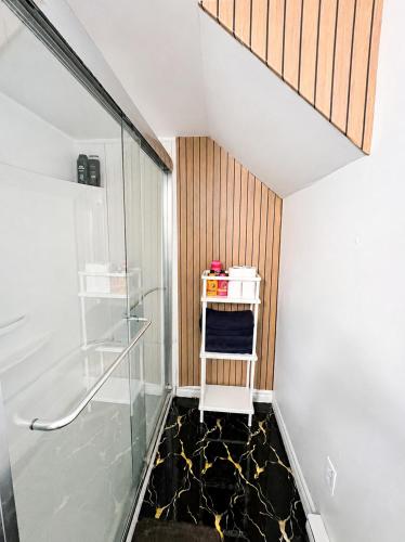 a bathroom with a glass shower and a black floor at Cozy 2-Bedroom Suite Near Moncton Hospital & NBCC in Moncton