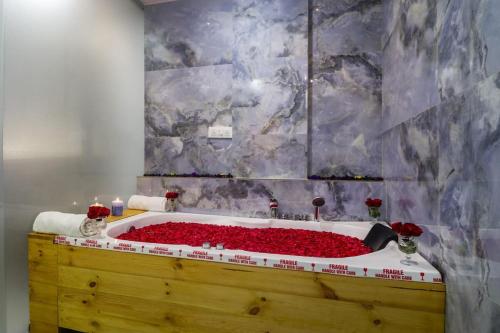 a bathroom with a bath tub filled with red roses at DSR Blue Suites in Hyderabad