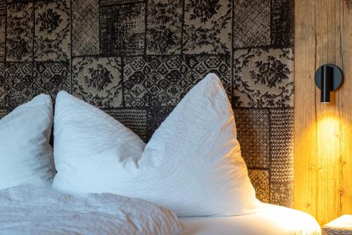a white bed with two pillows on top of it at Schössersmühle in Eisenberg