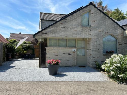 a brick house with a flower pot in front of it at Toezens in Ingelmunster