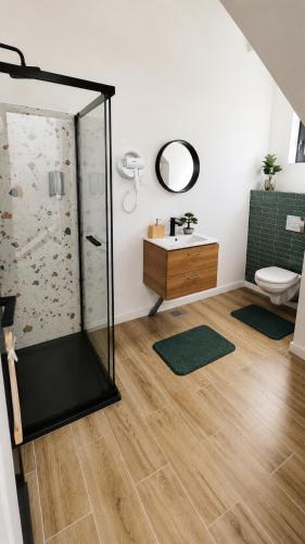 a bathroom with a shower and a sink and a toilet at Triovista Chalets in Nehoiu