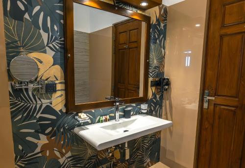 a bathroom with a sink and a mirror at At Kelly's Ambalangoda in Ambalangoda