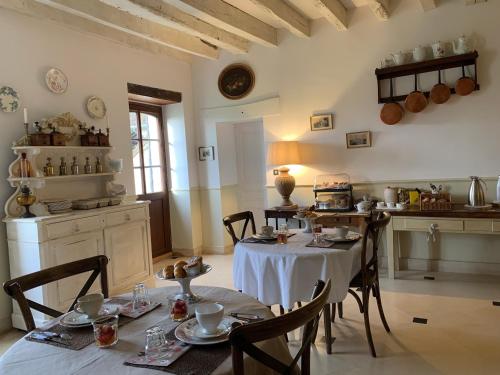 a kitchen with a table and chairs in a room at Le Clos du Cerf in Cellettes