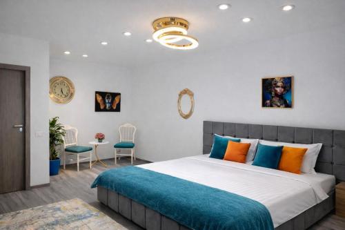 a bedroom with a large bed with blue and orange pillows at Le Charme Boutique in Bucharest
