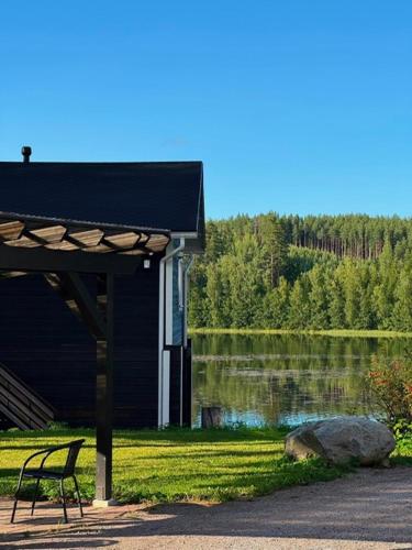 a bench sitting in front of a house next to a lake at Norppa Lake Resort in Savonlinna
