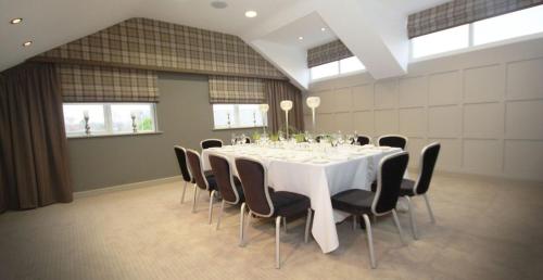 a dining room with a white table and chairs at Red Hall Hotel in Walmersley