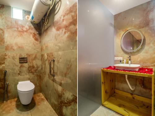 a bathroom with a toilet and a sink and a mirror at DSR Pink Suites in Hyderabad