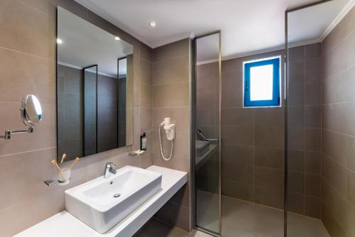 un bagno con lavandino e doccia di Lindos Portes Suites - Adults Only a Líndos
