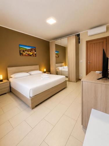 Grab a Flat in Coroneo في ترييستي: غرفة نوم بها سرير وجهاز تلفزيون