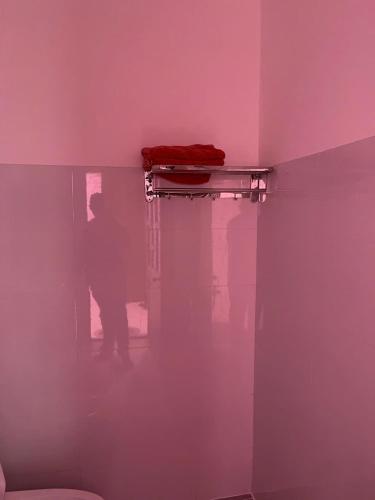 a man standing in a room with a pink wall at Khách Sạn Thành Châu 2 