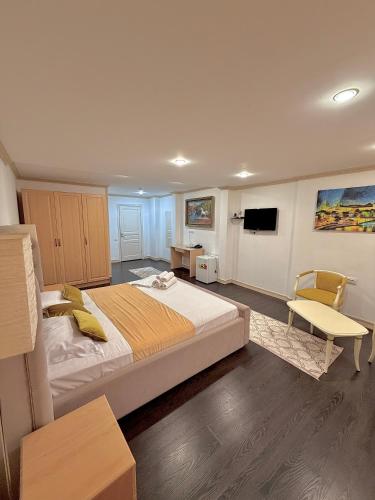a bedroom with a large bed and a tv at Djasmines Hotel Astana in Astana