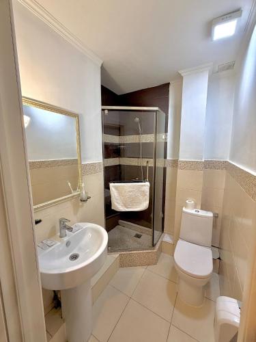 a bathroom with a sink and a toilet and a shower at Djasmines Hotel Astana in Astana