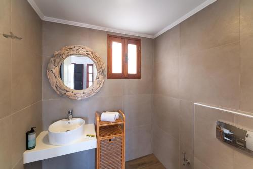 a bathroom with a sink and a mirror at Lindos Del Mar Suites - Adults Only in Lindos