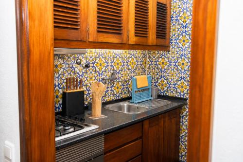a kitchen with a sink and a counter top at Spot Matur Apartment in Machico