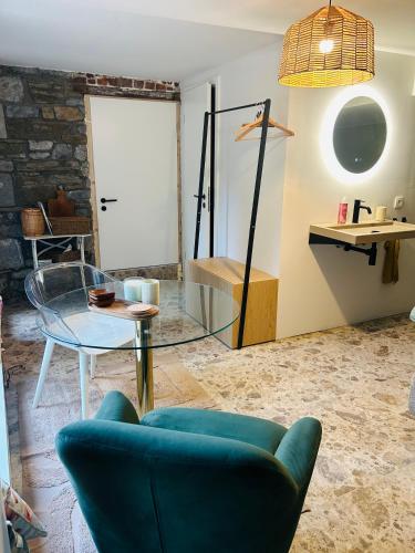 a living room with a blue couch and a glass table at Between hills and home in Trooz