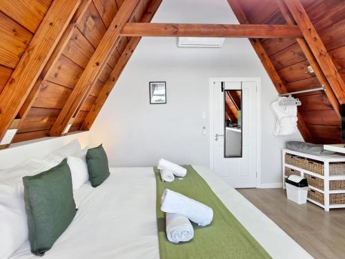 a bedroom with a white bed and wooden ceilings at Salt Boutique Guest House in Bloubergstrand