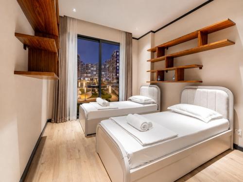 two beds in a room with a window at 7 Star Apartments in Tashkent