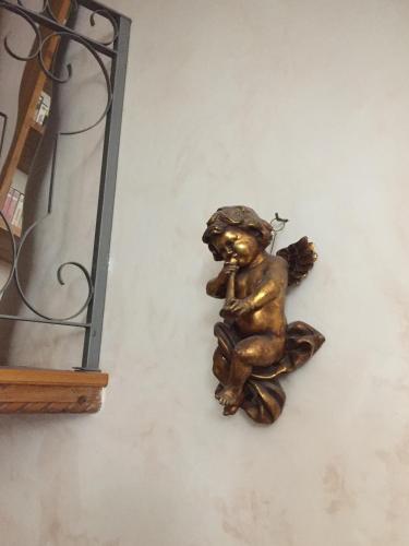 a bronze statue of a cherub sitting on a wall at Due Papi in Savona