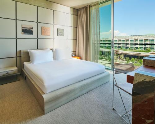 a bedroom with a bed and a large window at Voyage Kundu in Antalya
