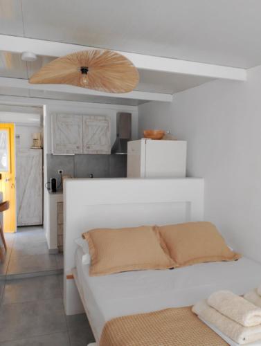 a bedroom with a white bed and a ceiling at Zacharias Seaside Studio Kimolos in Kimolos